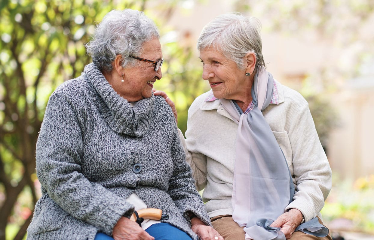 Outdoor, friends and bench with senior women, love and bonding together with retirement, park and cheerful. Old ladies, outside and mature people with conversation, group and joy with weekend break